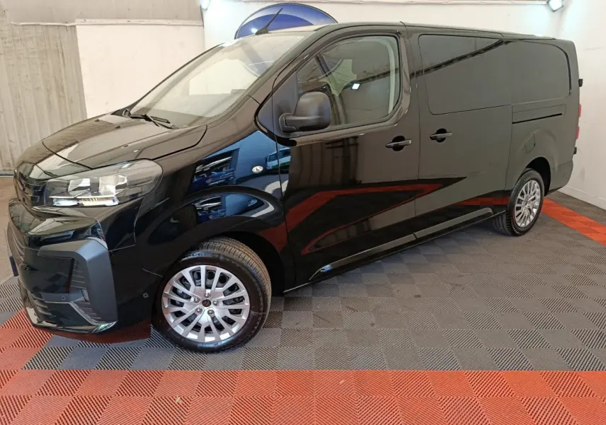 Vue 3/4 avant droit du Peugeot Expert Fourgon XL noir, avec jantes alliage et rétroviseurs noirs, dans un showroom.