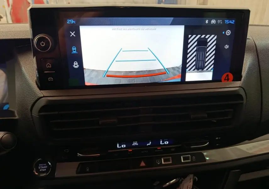 Vue rapprochée de l’écran tactile du tableau de bord du Peugeot Expert Fourgon XL noir, affichant la caméra de recul et l’aide au stationnement.