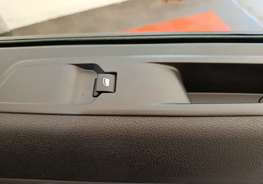 Gros plan sur le bouton de commande de vitre électrique sur la porte intérieure d’un Peugeot Expert Fourgon noir.
