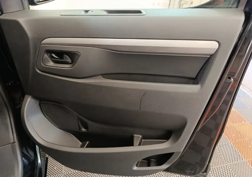 Vue rapprochée de la porte côté gauche noire du Peugeot Expert Fourgon XL 2026, avec poignée et rangement intégré.