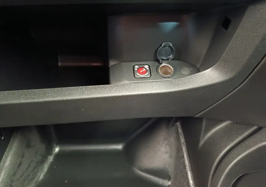 Gros plan intérieur sur la prise 12V et le rangement sous le tableau de bord du Peugeot Expert Fourgon noir.