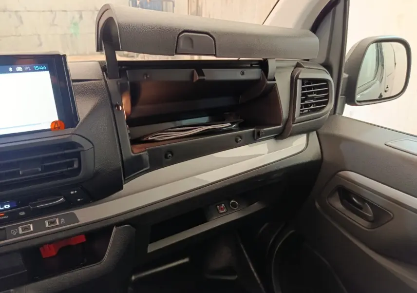 Intérieur du Peugeot Expert Fourgon XL 2026, vue côté passager avec boîte à gants ouverte et tableau de bord noir et gris.