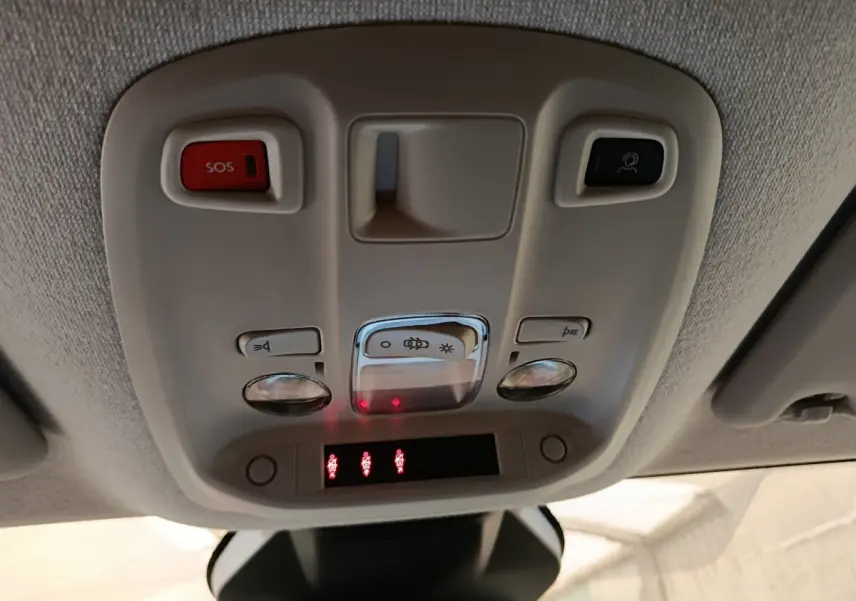 Vue intérieure en gros plan du plafonnier gris avec boutons SOS et commandes d'éclairage du Peugeot Expert Fourgon noir.