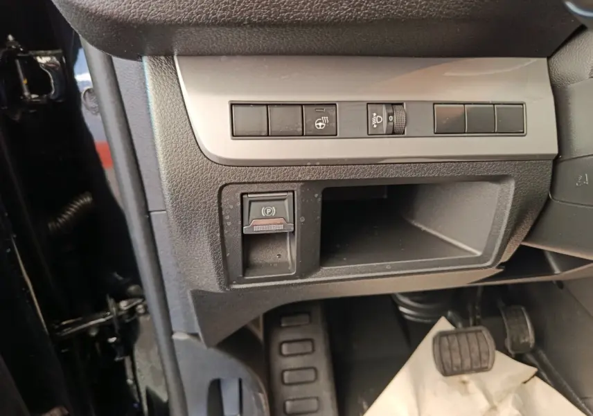 Gros plan sur la console inférieure côté conducteur du Peugeot Expert Fourgon noir, avec commandes et pédales visibles.