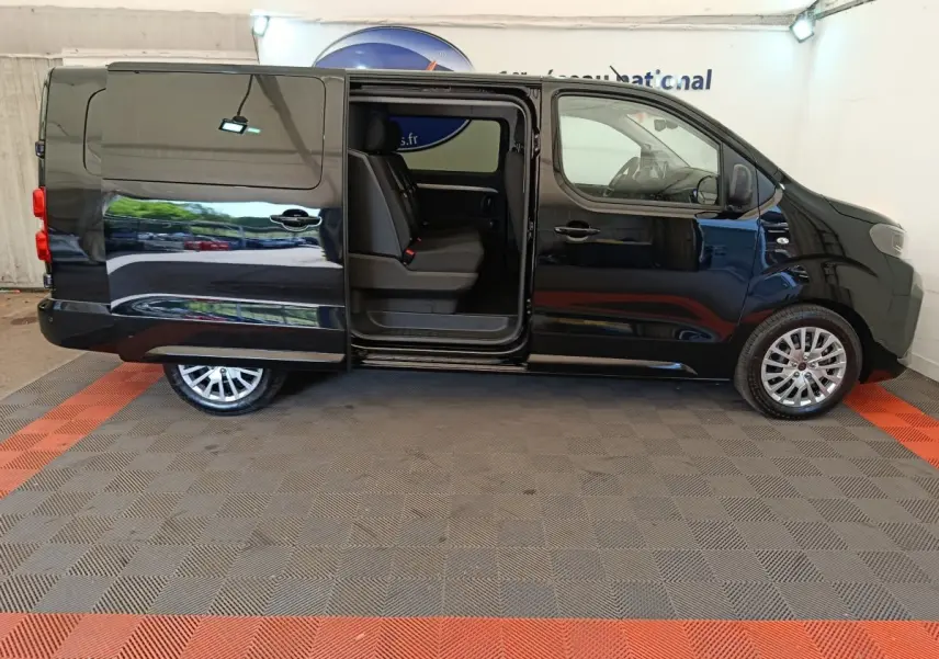 Vue latérale droite d’un Peugeot Expert Fourgon XL noir avec porte coulissante ouverte dévoilant les sièges arrière.