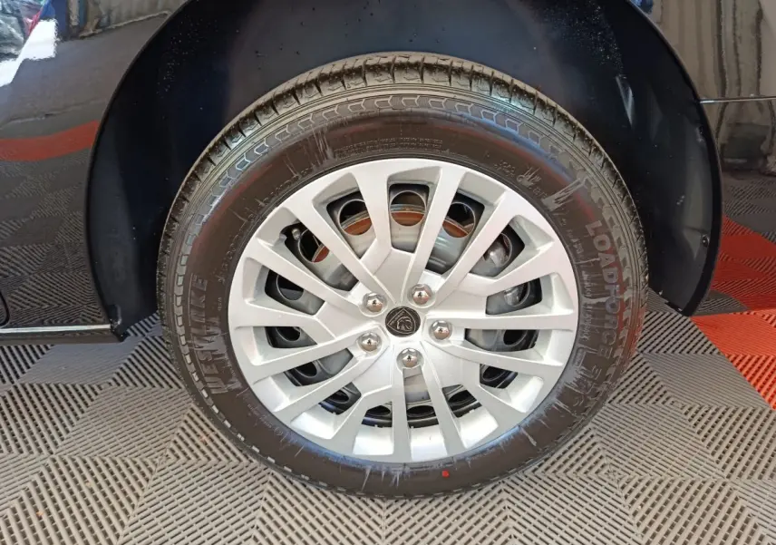 Gros plan sur la roue avant gauche noire du Peugeot Expert Fourgon XL Diesel 2026 avec jante argentée et logo Peugeot central.