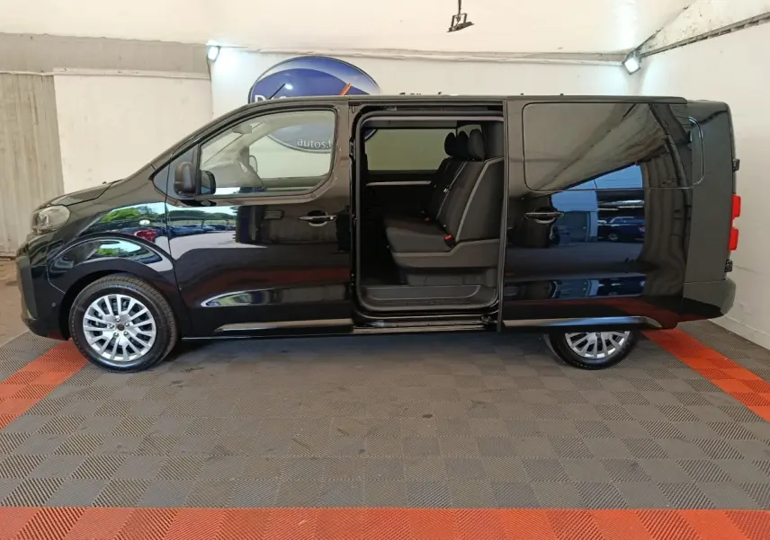 Vue latérale gauche d'un Peugeot Expert Fourgon XL noir avec porte coulissante ouverte montrant la banquette arrière trois places.