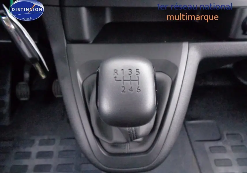 Vue intérieure centrée sur le volant Peugeot d'un Expert Cabine Approfondie gris, avec tableau de bord et levier de vitesses manuelle visible.