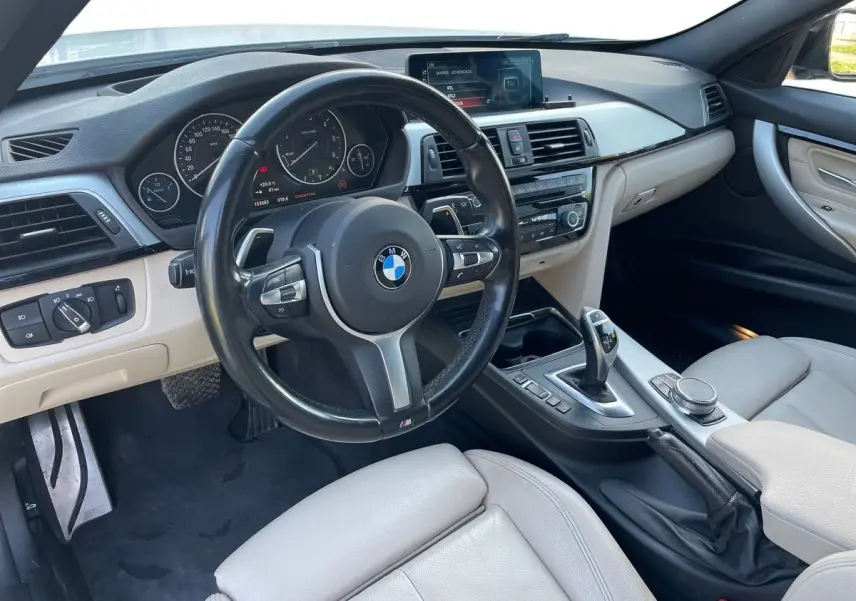 Intérieur clair de BMW Série 3 Touring F31 330DA XDrive 2017, vue côté conducteur sur tableau de bord et volant M Sport.