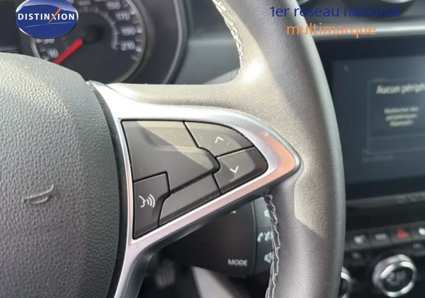 Gros plan sur les commandes au volant en cuir noir du Dacia Duster 2022, version ECO-G 100 Prestige.