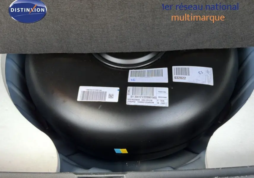 Vue rapprochée du réservoir GPL noir installé dans le coffre du Dacia Duster bleu Iron 2022.