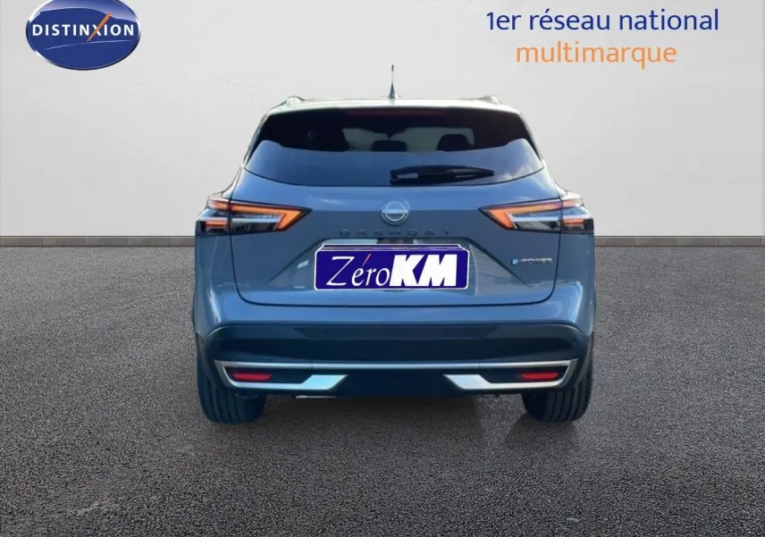 Vue arrière d'un Nissan Qashqai 1.5 E-POWER gris argile métal avec feux LED et logo distinctif.