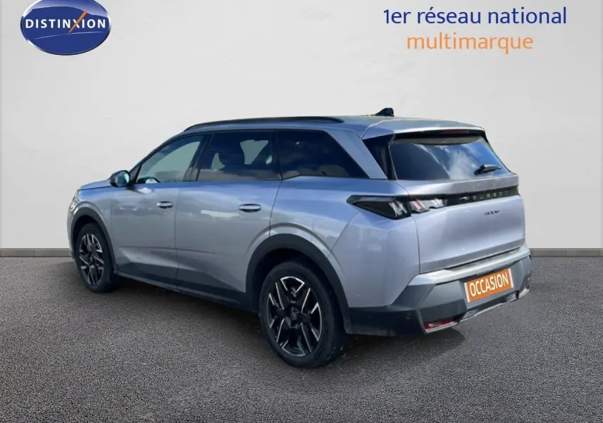 Peugeot 5008 gris Artense métal en 3/4 arrière droit, avec jantes noires et toit panoramique visible.