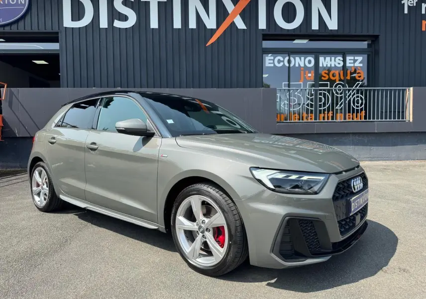 Audi A1 Sportback gris vue 3/4 avant droit, jantes alliage et étriers de frein rouges visibles.