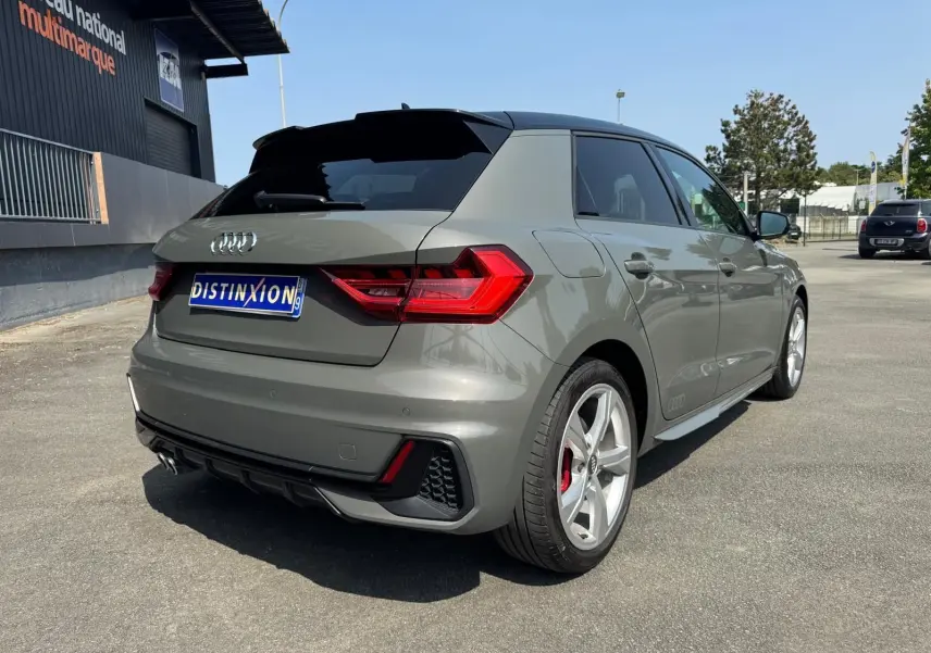 Audi A1 Sportback gris vue 3/4 arrière droit, avec jantes sport et feux arrière LED distinctifs.