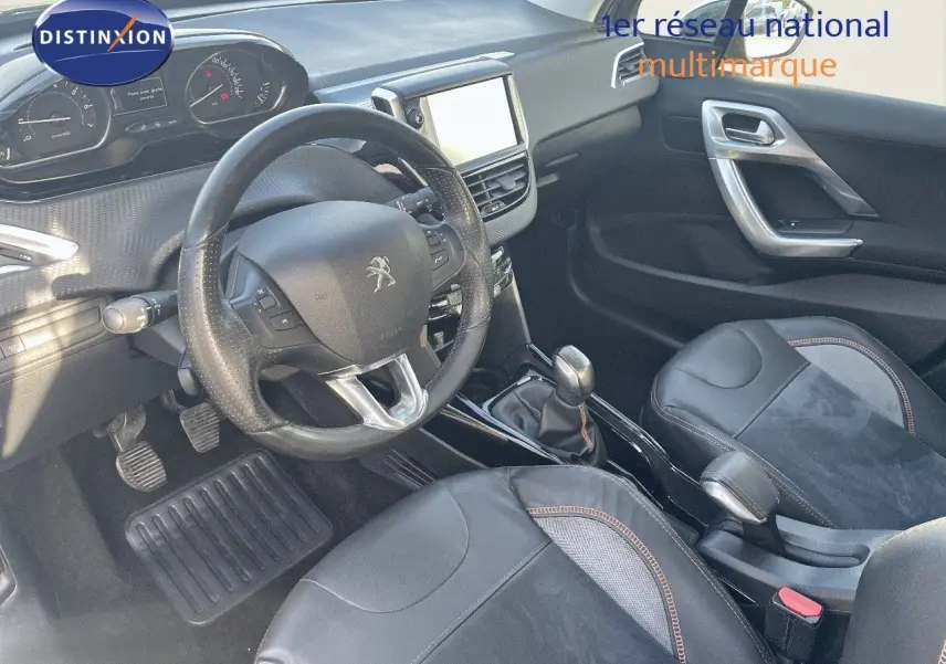 Vue intérieure côté conducteur du Peugeot 2008 gris platinium, avec volant cuir et console centrale équipée d'un écran tactile.