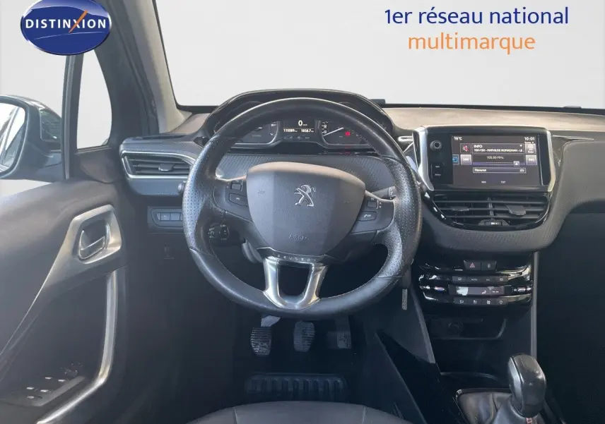 Vue intérieure centrée sur le volant et tableau de bord du Peugeot 2008 gris platinium de 2019.