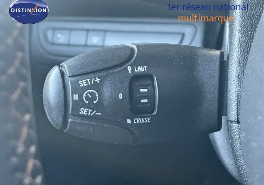 Gros plan sur la commande de régulateur de vitesse du Peugeot 2008 gris platinium, côté gauche du volant.