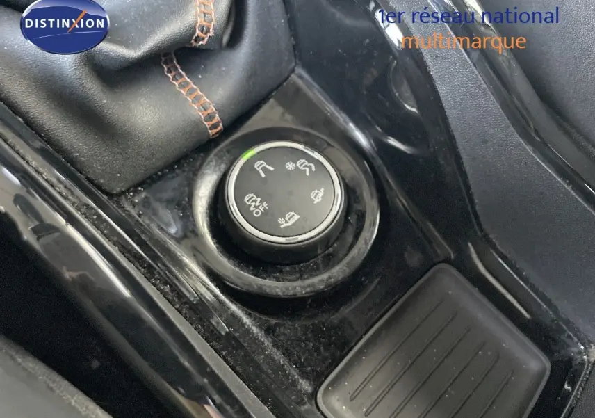 Gros plan sur la molette de sélection des modes de conduite dans l'habitacle noir d'une Peugeot 2008 gris platinium.