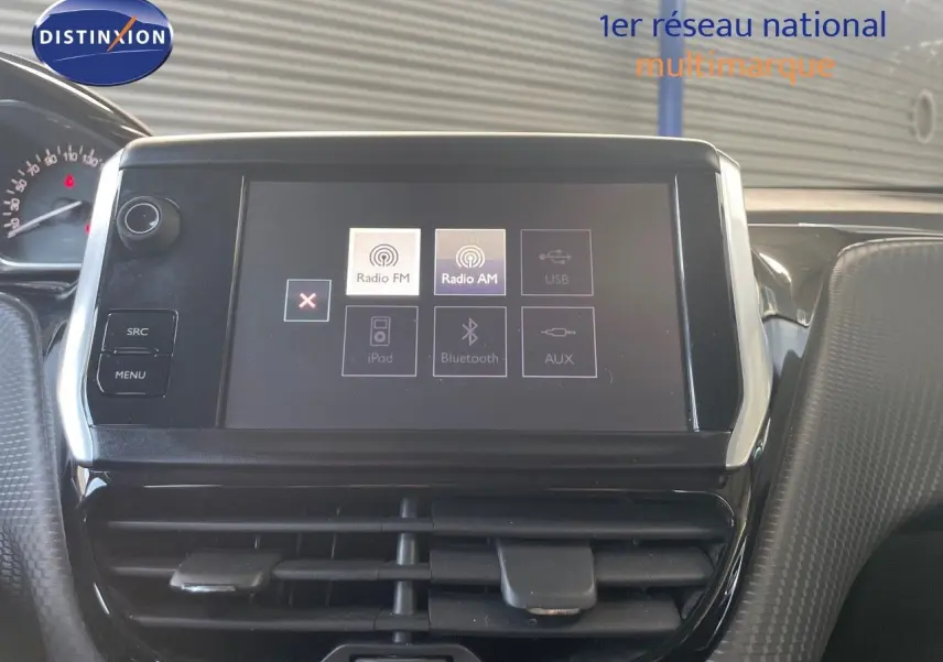 Écran tactile central du tableau de bord d'une Peugeot 2008 gris platinium, avec options radio et Bluetooth visibles.