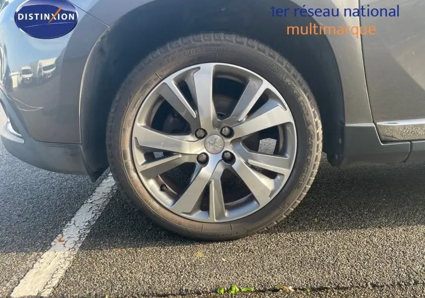Gros plan sur la roue avant gauche gris platinium métal d'un Peugeot 2008 Crossway 2019, jante alliage biton.