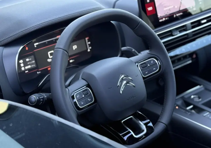 Vue rapprochée du volant noir et du tableau de bord numérique du Citroën C5 Aircross 2025, intérieur moderne.