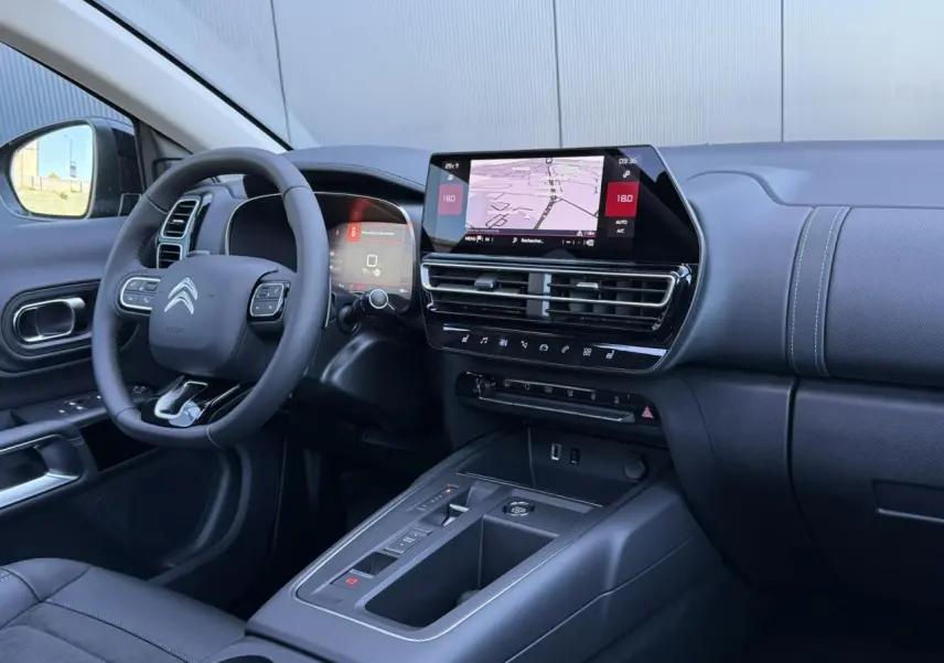 Intérieur noir du Citroën C5 Aircross 2025, vue côté conducteur sur tableau de bord et écran tactile GPS.