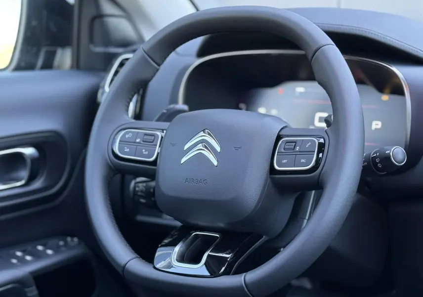 Volant cuir noir avec commandes intégrées du Citroën C5 Aircross 2025, vue rapprochée côté conducteur intérieur