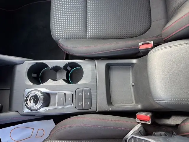 Vue plongeante sur la console centrale de la Ford Focus 1.5 EcoBoost 150ch ST-Line 2022, avec boîte auto et sièges noirs à surpiqûres rouges.