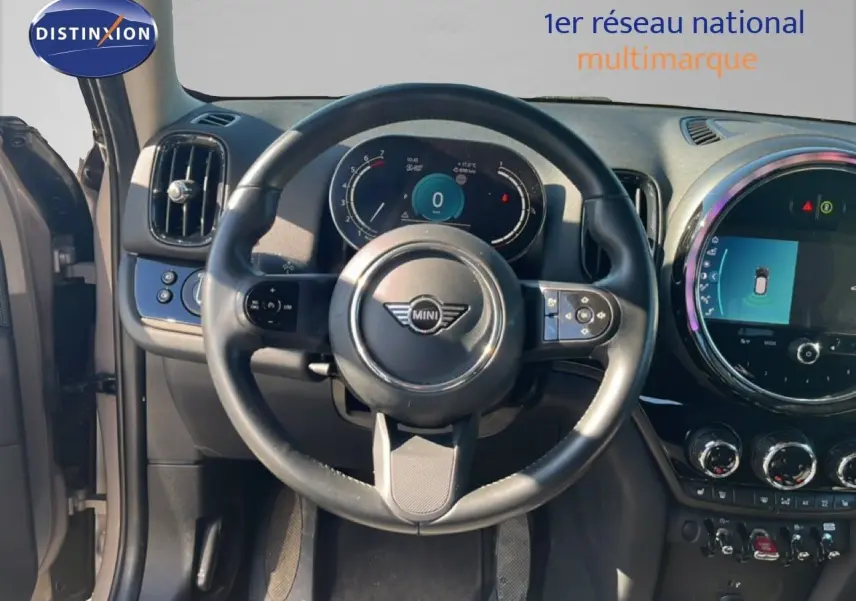 Vue intérieure centrée sur le volant et le tableau de bord numérique d'une MINI Countryman 2023, finition Essential.