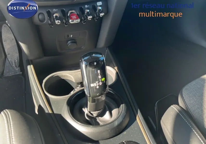 Gros plan sur la console centrale du MINI Countryman 2023, montrant le levier de vitesse automatique et les commandes environnantes.