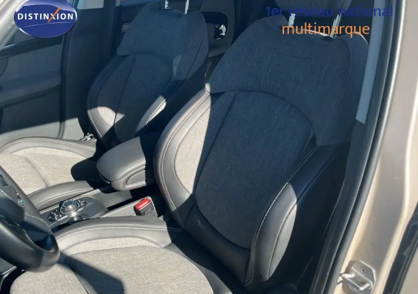 Vue intérieure côté avant droit du MINI Countryman 2023 avec sièges tissu gris et cuir noir, porte ouverte.