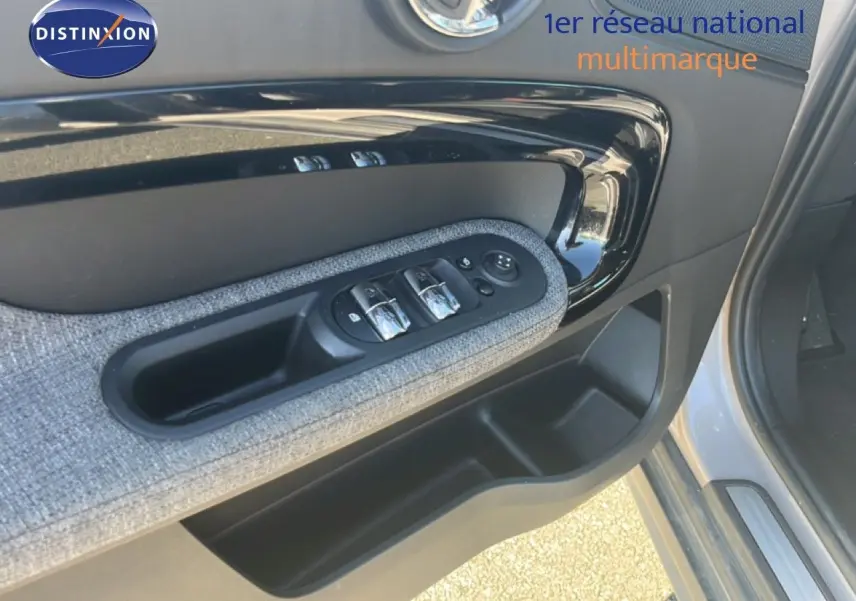 Gros plan sur la porte avant gauche de la MINI Countryman 2023 en rooftop grey, avec commandes de vitres et habillage tissu.