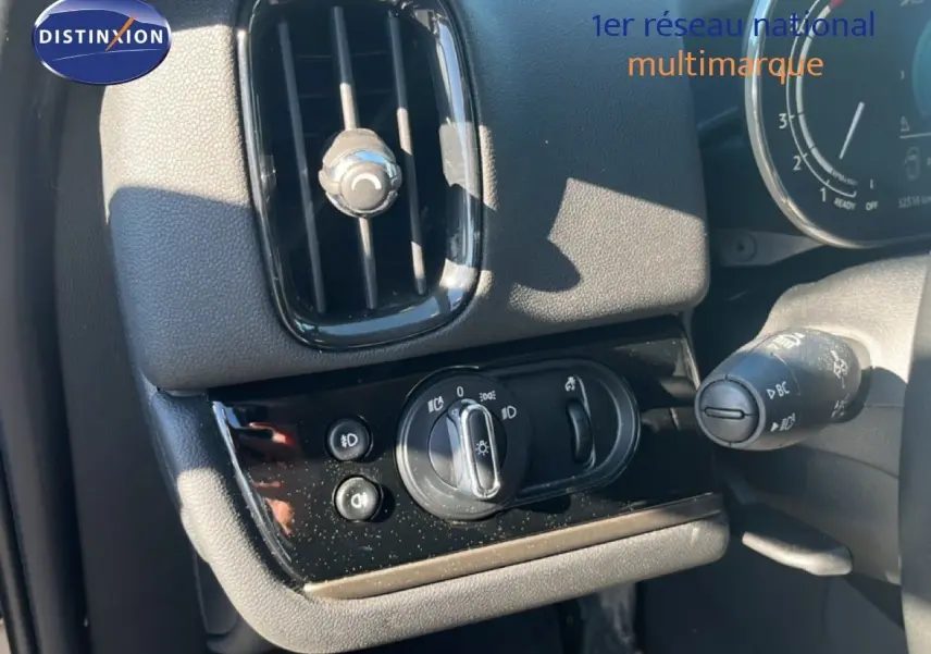 Détail du tableau de bord côté gauche du MINI Countryman Cooper 2023 en rooftop grey, montrant les commandes d'éclairage et la sortie d'air.