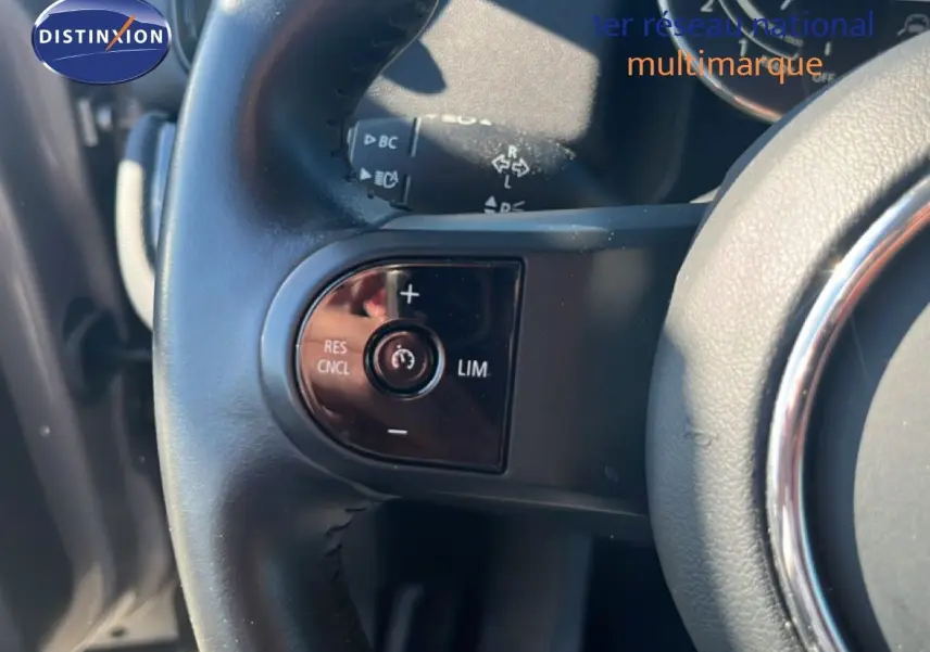 Gros plan sur la partie gauche du volant en cuir noir du MINI Countryman 2023, avec commandes intégrées.