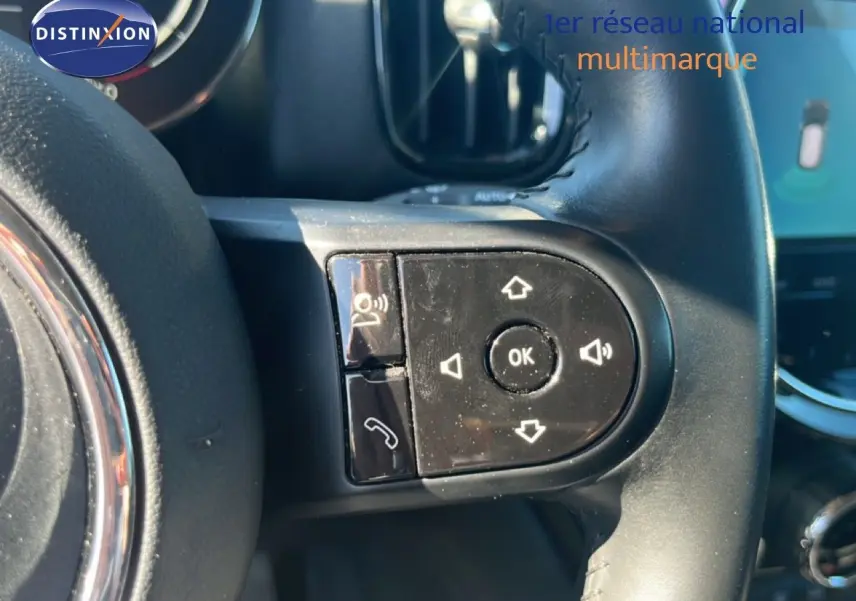 Gros plan sur les commandes au volant à gauche d'une MINI Countryman 2023 couleur Rooftop Grey Metal.