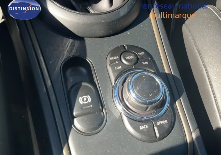 Gros plan sur la console centrale avec molette de contrôle et frein à main électrique du MINI Countryman 2023.