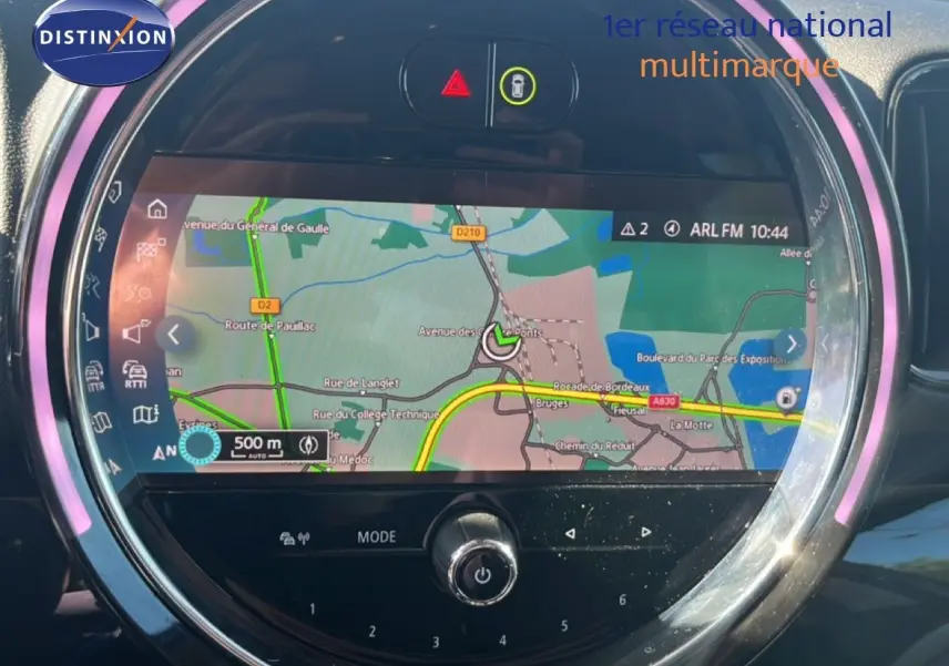 Écran central rond du MINI Countryman 2023 affichant la navigation GPS avec interface lumineuse LED rose pâle.