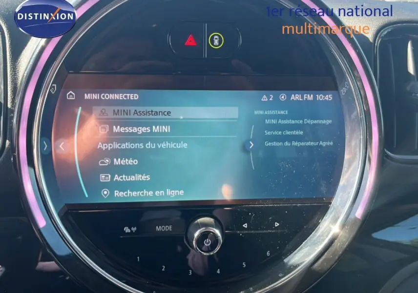 Écran central tactile du MINI Countryman Cooper 2023 avec interface MINI Connected et éclairage d’ambiance rose.