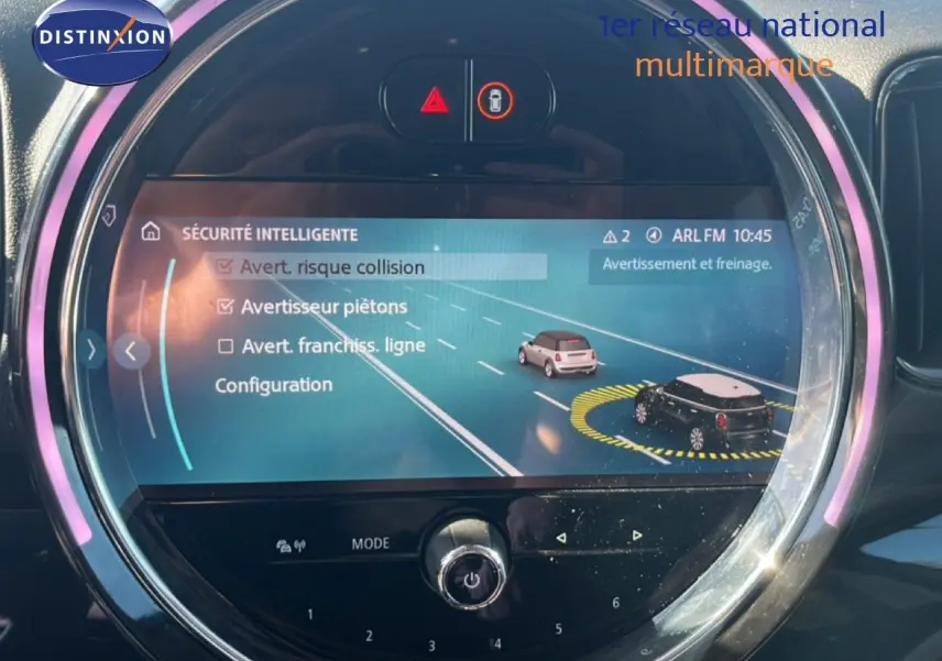 Écran central rond du MINI Countryman 2023 affichant les options de sécurité intelligente, avec éclairage LED rose autour.