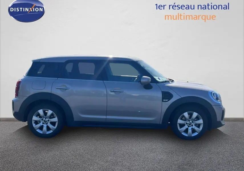 Profil côté gauche d'une MINI Countryman Cooper 2023 en gris rooftop, avec jantes alliage et toit contrasté blanc.