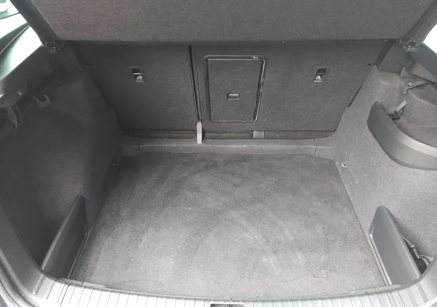 Coffre spacieux de SKODA KAROQ gris 2021, vue intérieure montrant le tapis et les sièges arrière rabattables.