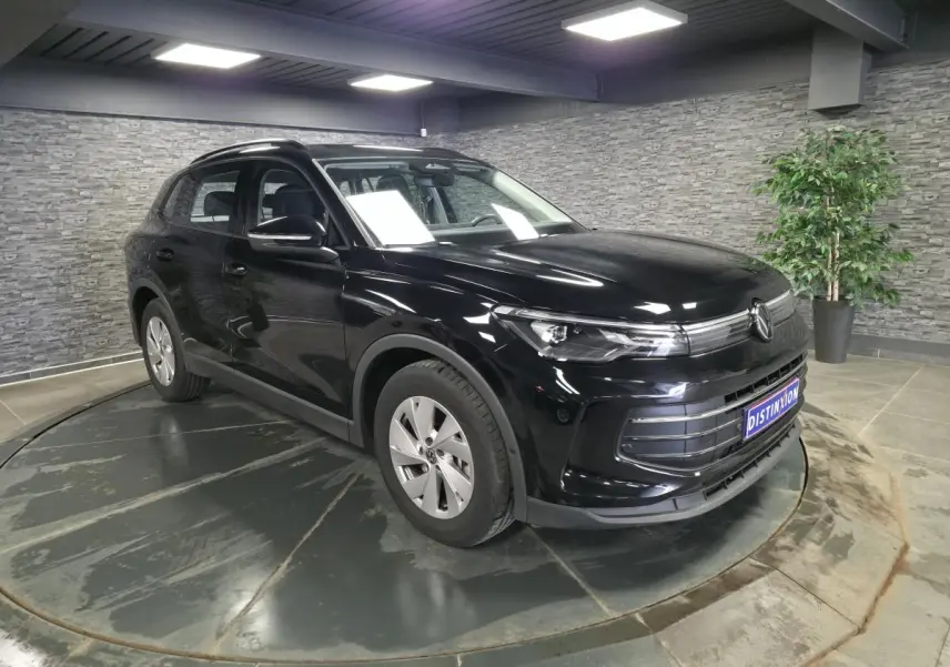 Volkswagen Tiguan 2025 noir métallisé en 3/4 avant gauche, avec jantes alliage 17 pouces et calandre distinctive.
