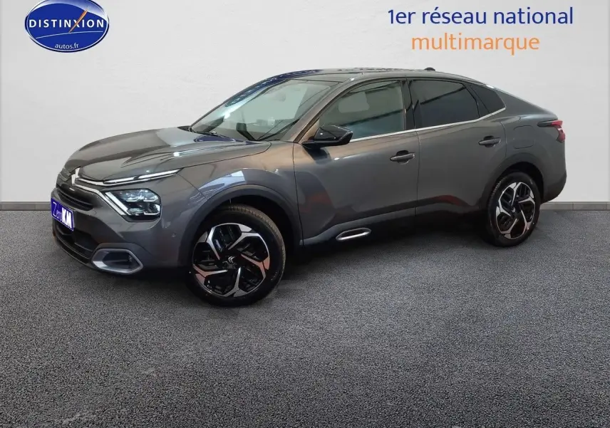Citroën C4 X gris platinium métal en 3/4 avant droit, avec jantes bi-ton et lignes fluides modernes.