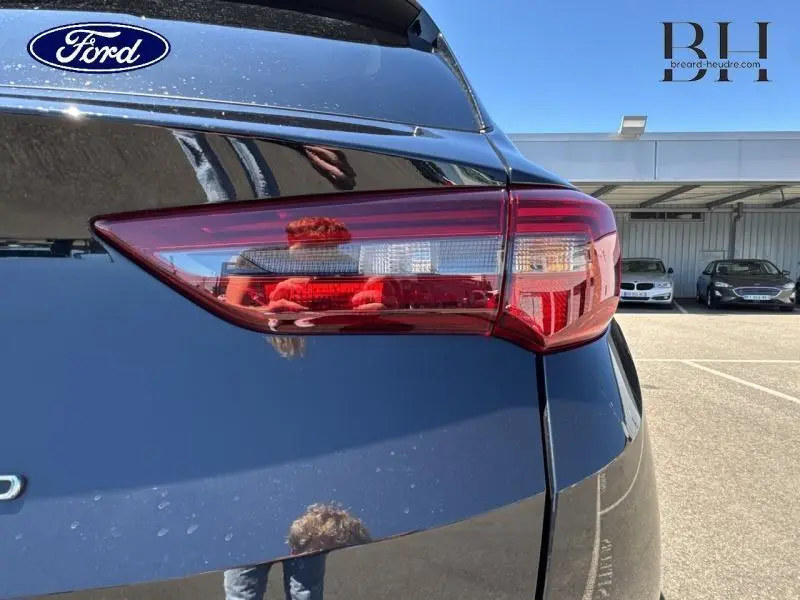 Gros plan sur le feu arrière droit d'un Opel Grandland noir diamant métallisé, soulignant ses lignes modernes et brillantes.