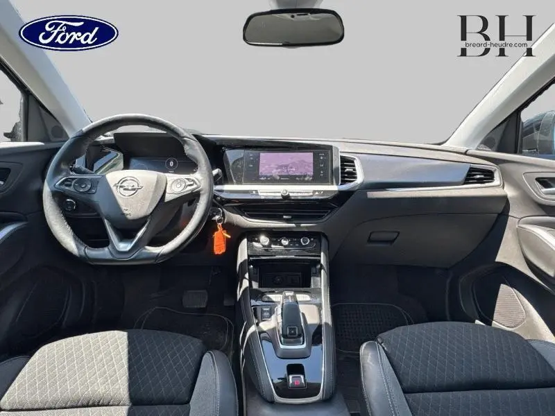 Intérieur avant d'un Opel Grandland noir, vue du poste de conduite avec volant cuir multifonction et écran tactile central.