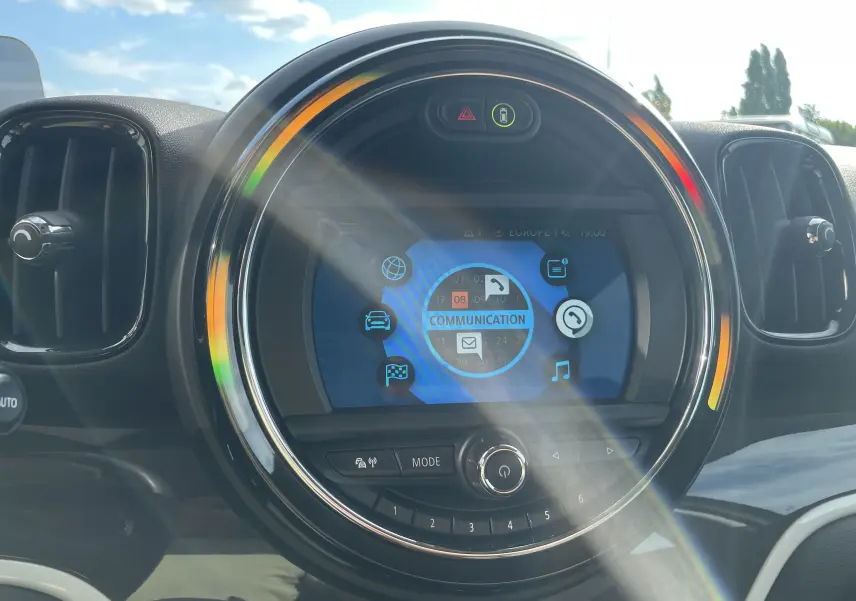 Gros plan sur l'écran central rond du tableau de bord du MINI Countryman F60 Moonwalk Grey, avec affichage multimédia coloré.