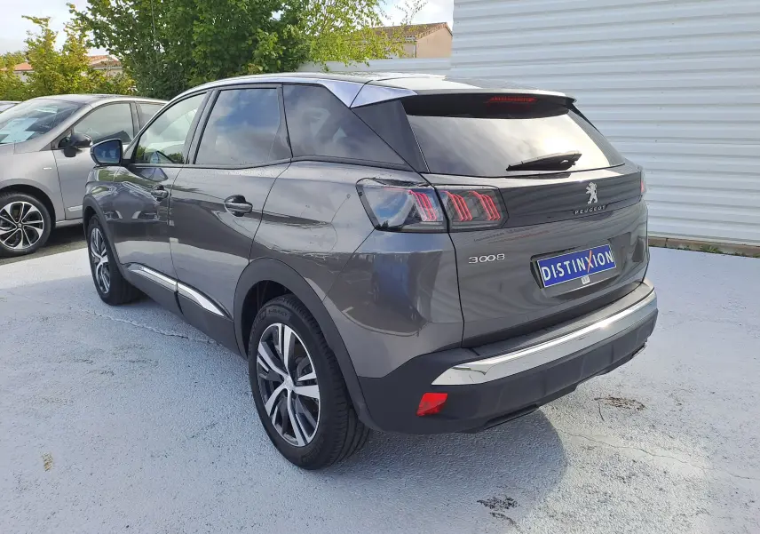 Vue 3/4 arrière droite d'un Peugeot 3008 gris platinium avec feux arrière à trois griffes et jantes alliage.