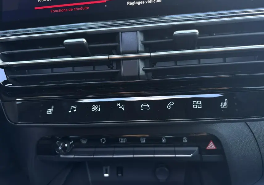 Gros plan sur la console centrale noire du Citroën C5 Aircross 2025 avec commandes tactiles et aérateurs horizontaux.