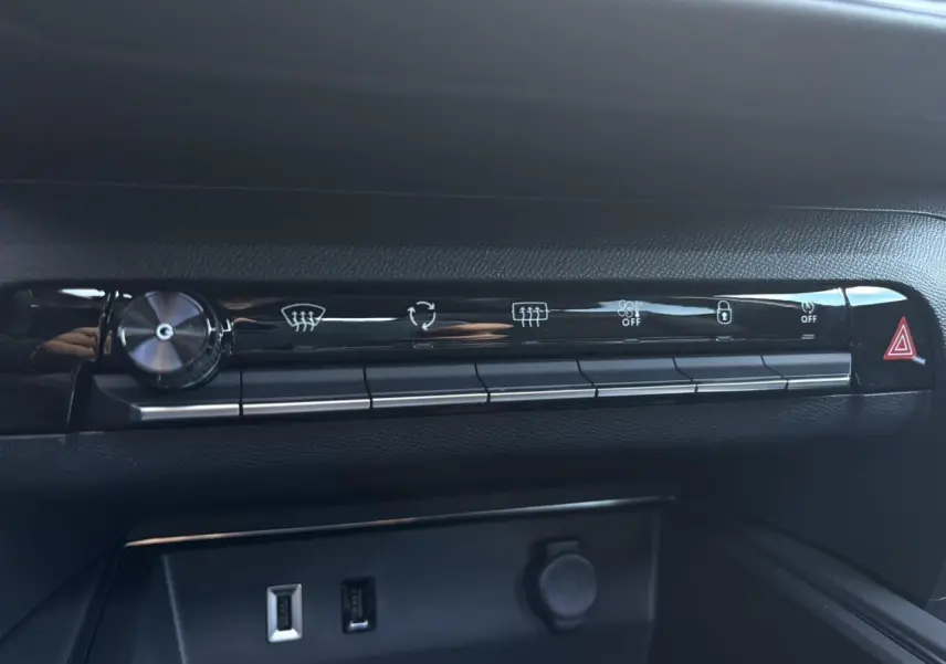 Vue rapprochée de la rangée de boutons de commande noire brillante et prises USB du tableau de bord du Citroën C5 Aircross gris.